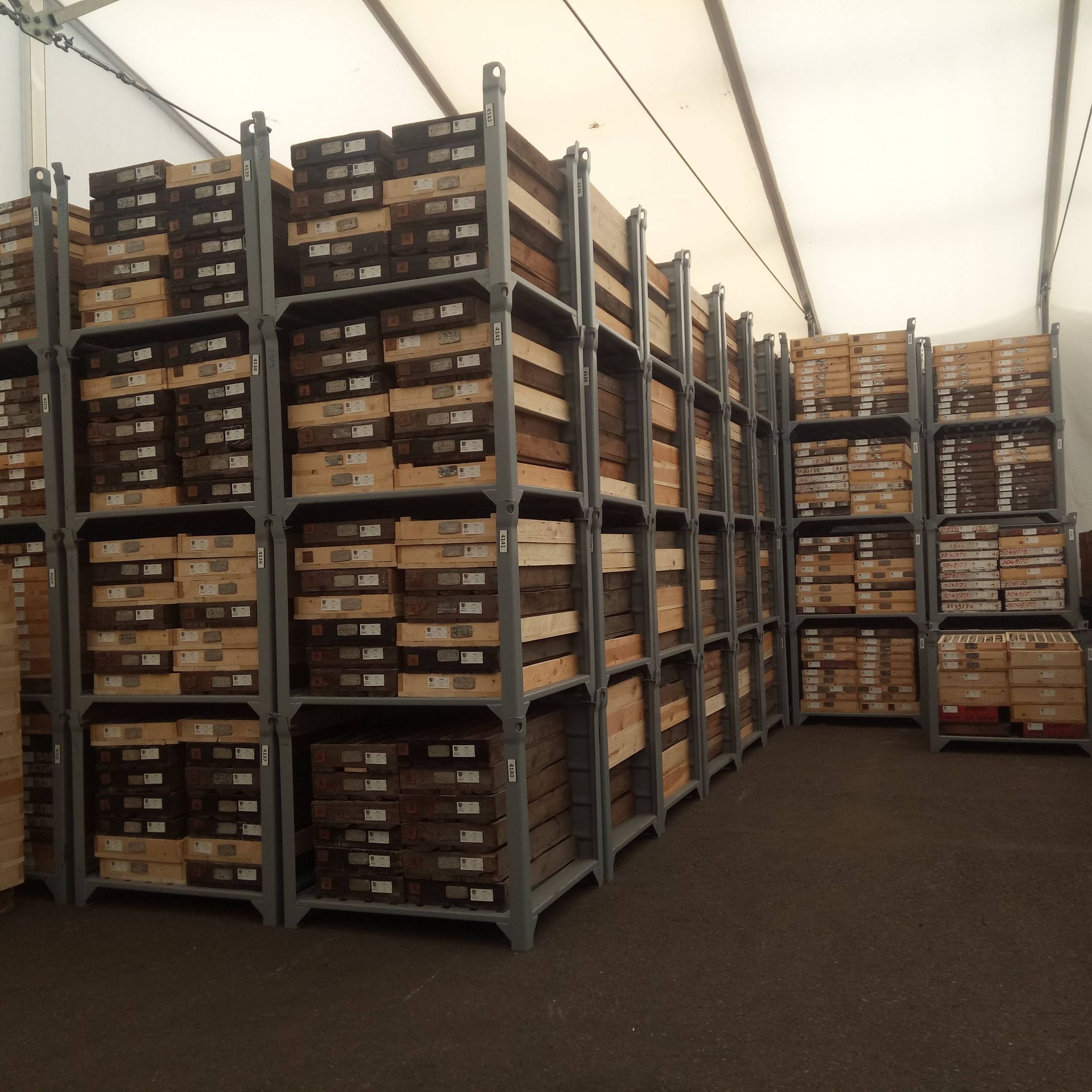 Regale voller gestapelter Holzplanken in einer Lagerhalle.