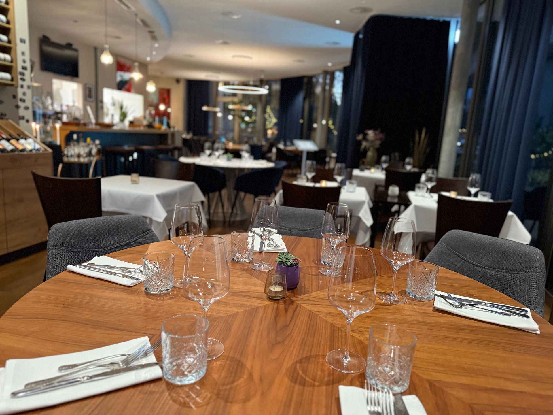 Ein Tisch mit Tellern voller Essen, darunter Steak, und Gläsern Wein. Foto vom SIMPLE STEAKHOUSE & TAPAS BAR