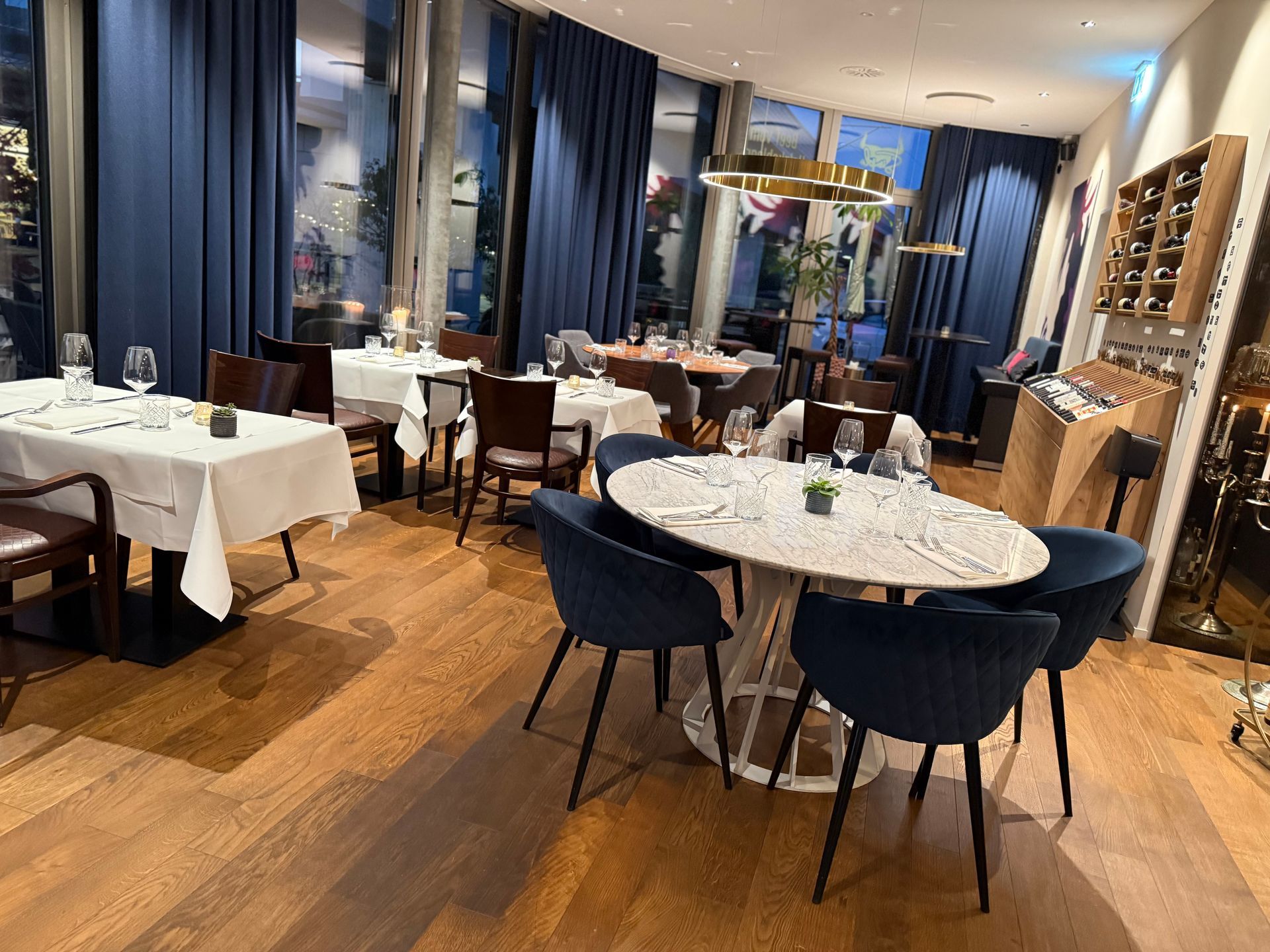 Eine Person brät mit einem Pfannenwender Fleisch auf einem Grill.