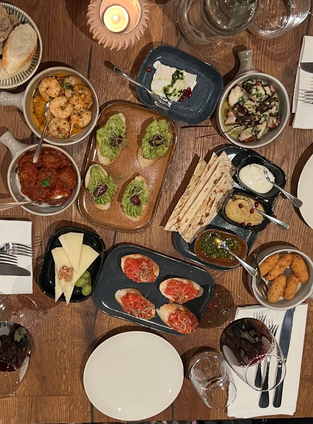 Eine Bar mit Tellern voller Essen und einem Getränk darauf. Foto vom SIMPLE STEAKHOUSE & TAPAS BAR