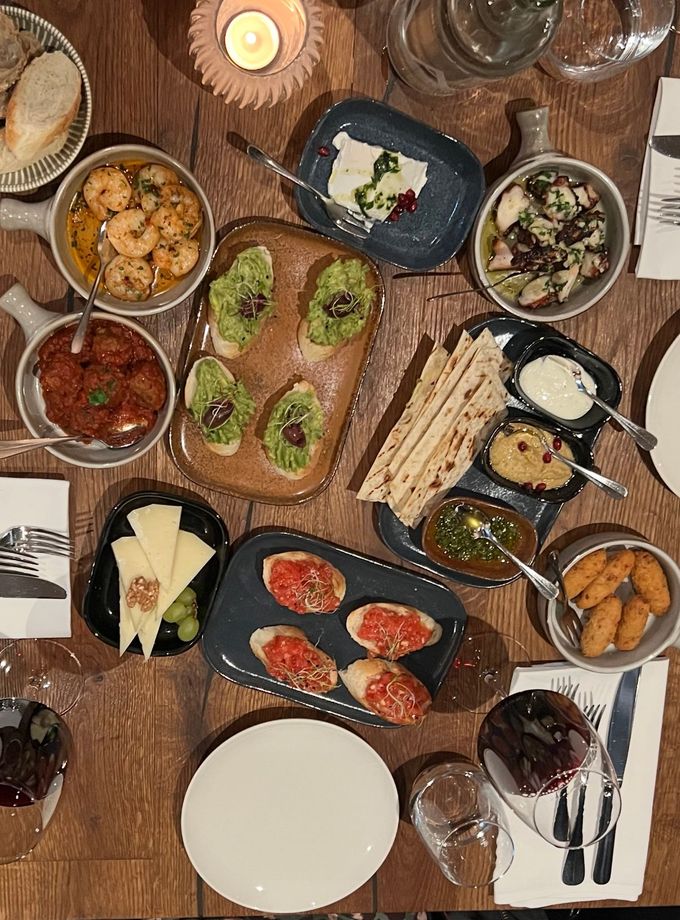 Eine Bar mit Tellern voller Essen und einem Getränk darauf. Foto vom SIMPLE STEAKHOUSE & TAPAS BAR