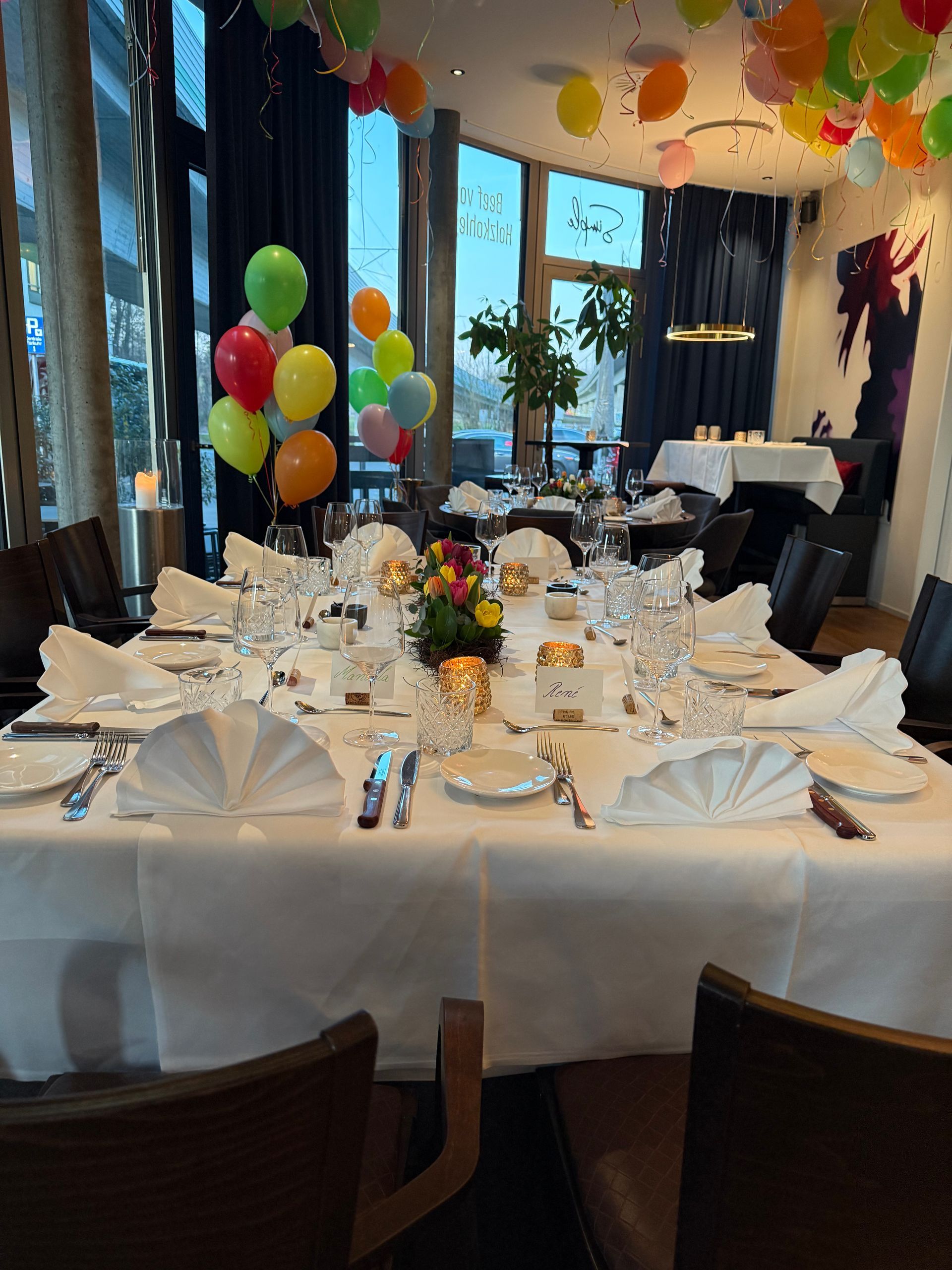 Ein mit Luftballons und Tischen dekorierter Rasen für eine Party