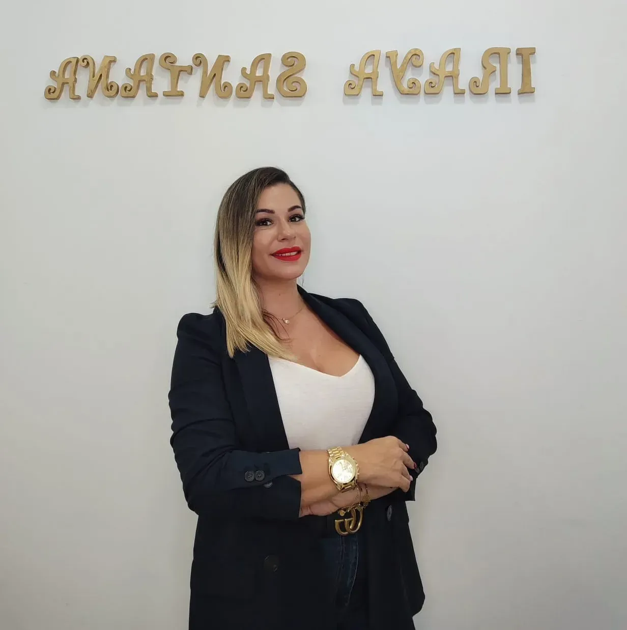 Una mujer con una camisa negra está parada frente a un cartel que dice amayab avai