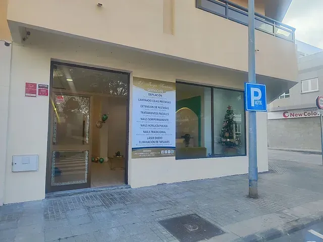 Un edificio con un cartel de estacionamiento enfrente.