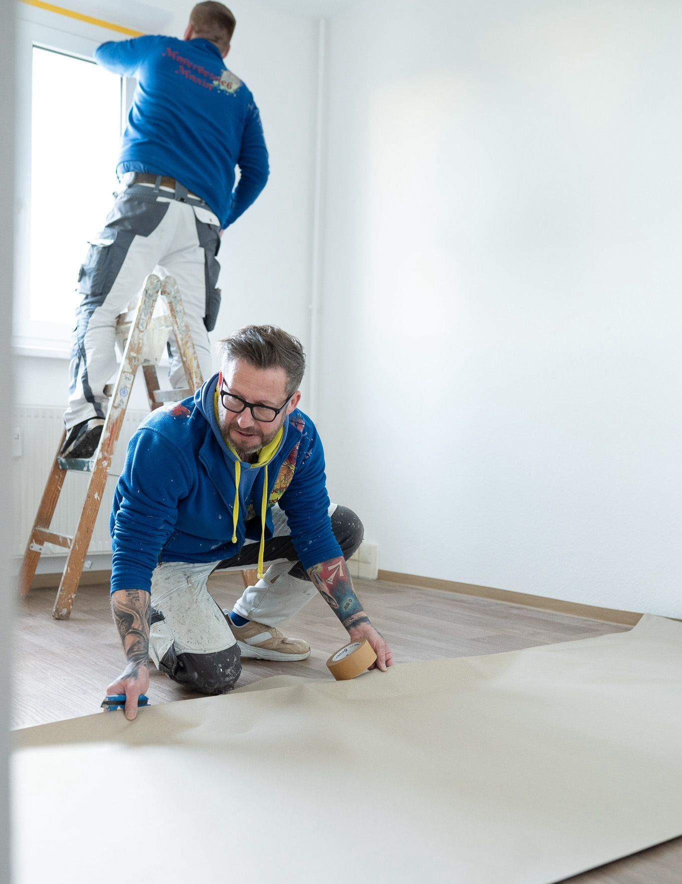 Ein Mann legt ein Stück Vinylbodenbelag auf den Boden.