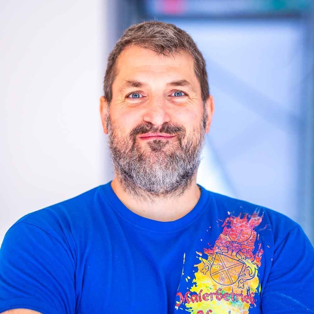 Ein Mann mit Bart trägt ein blaues Hemd