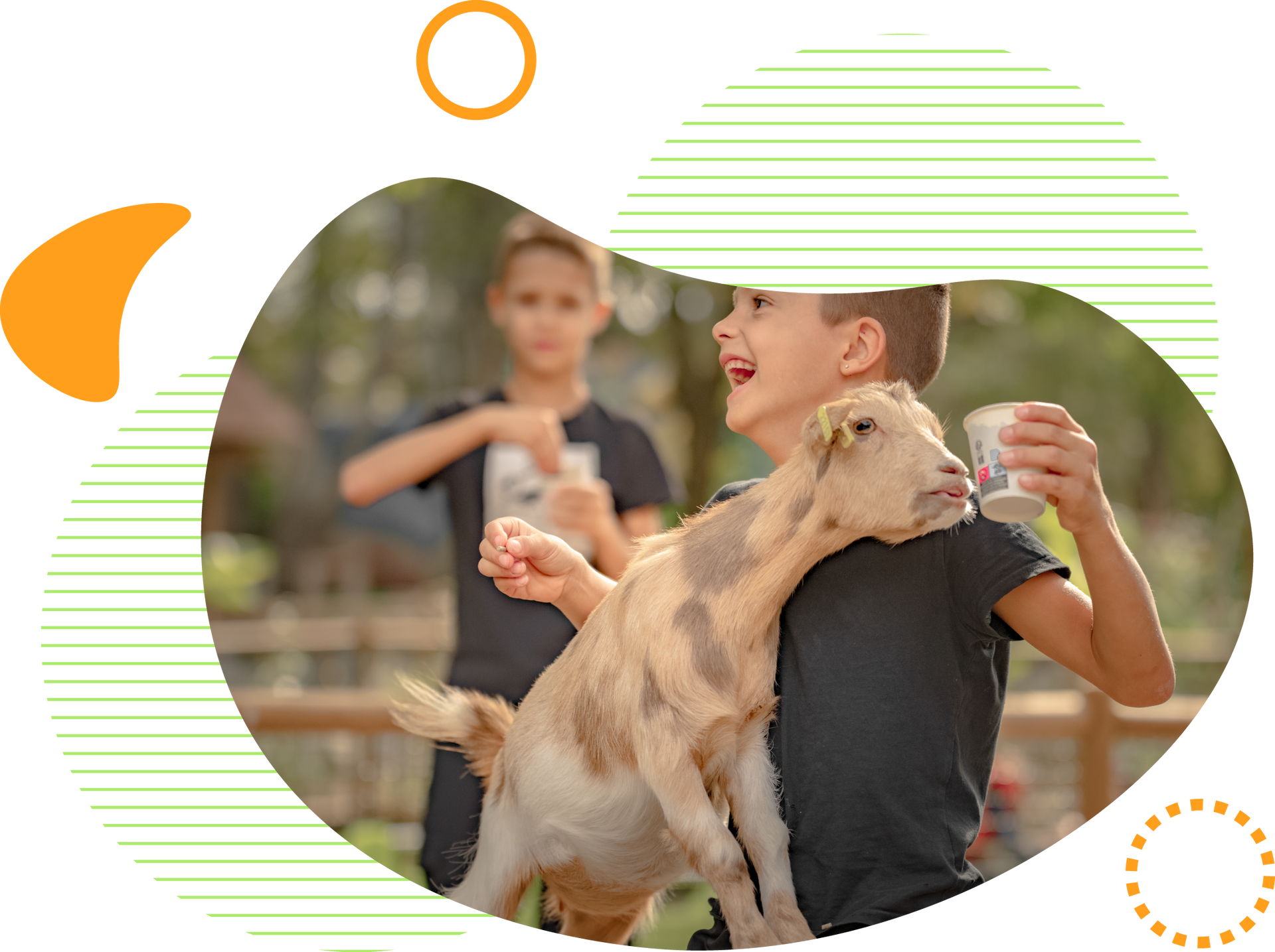 Un garçon donne du lait à une chèvre ; un autre garçon les observe. Tous deux sourient en plein air.