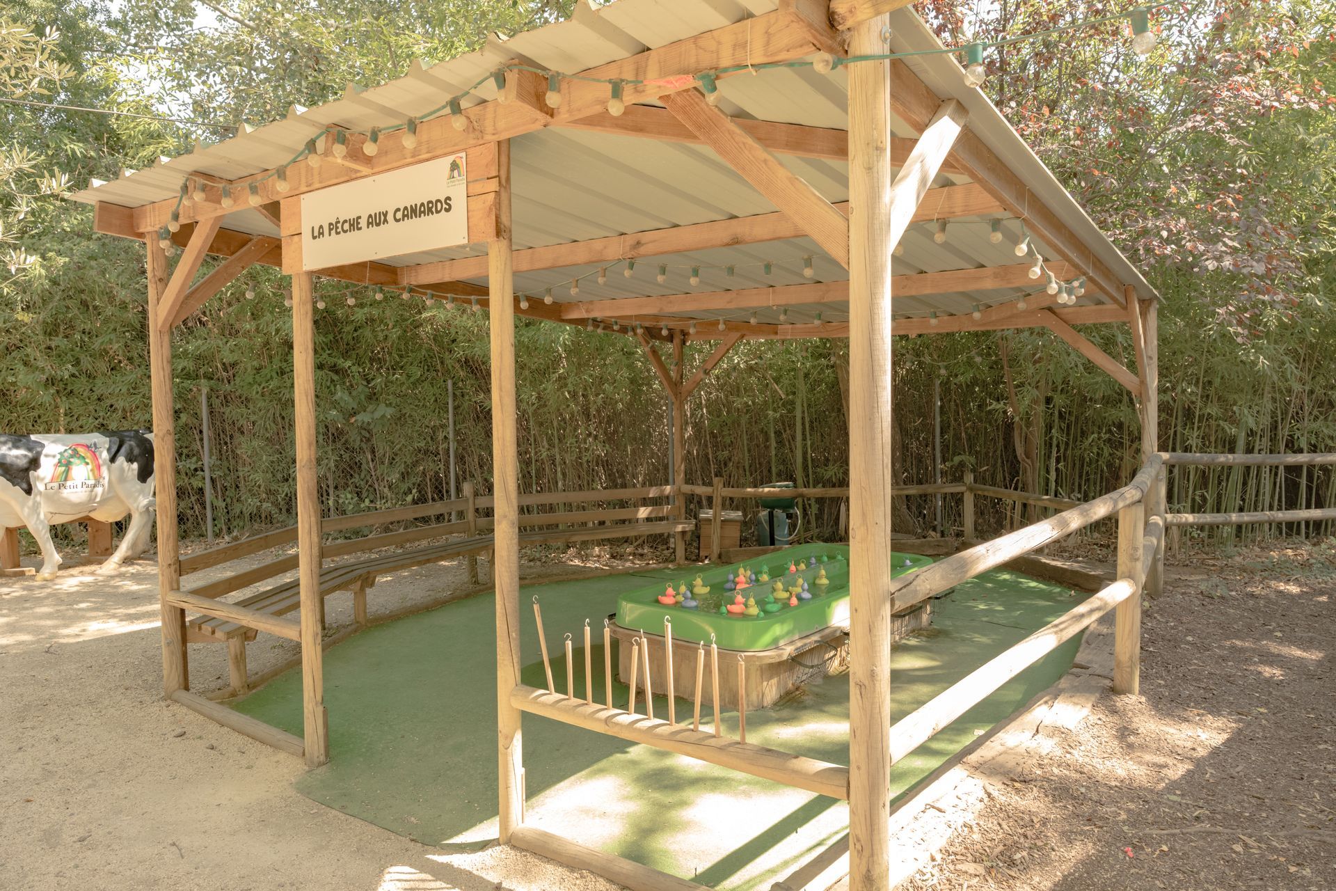Structure en bois avec une table, un toit et une surface végétale. En extérieur.