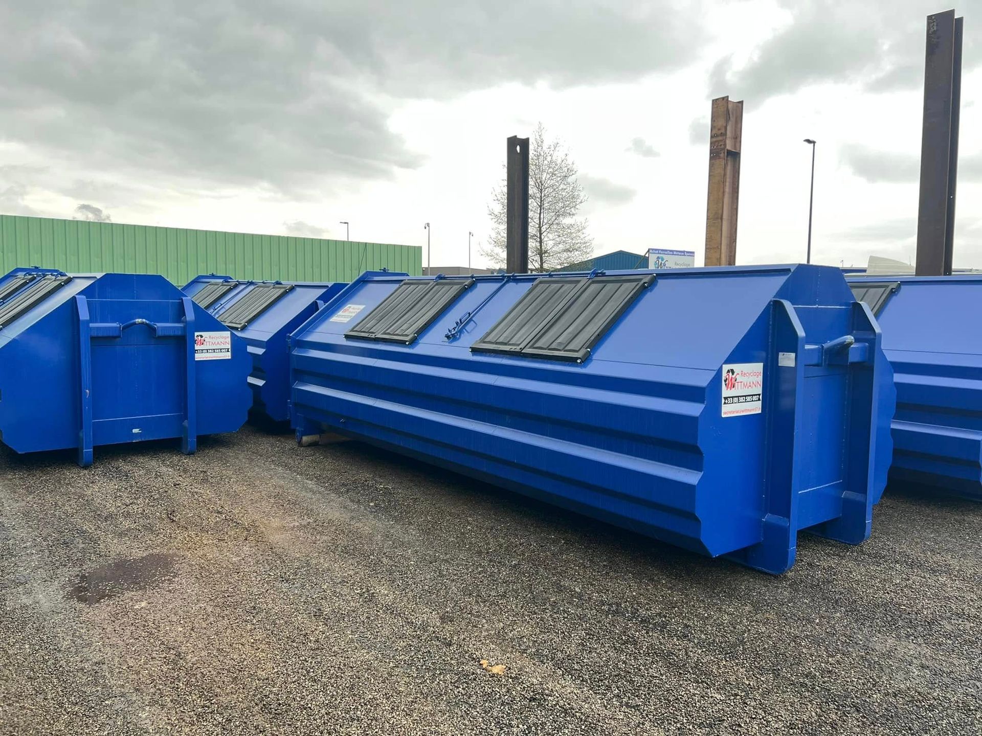 Plusieurs bennes sécurisées posées sur le sol.