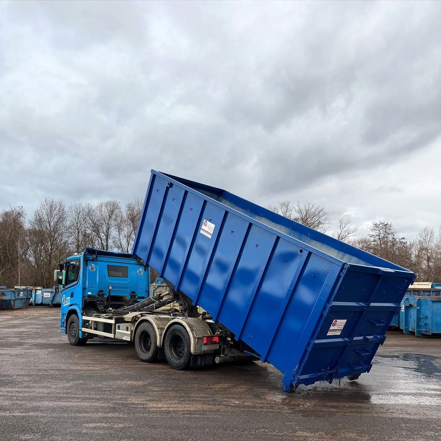 Un poids lourd basculant une benne ouverte.