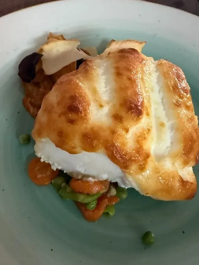 Huevos fritos sobre arroz con verduras mixtas en un tazón azul claro.