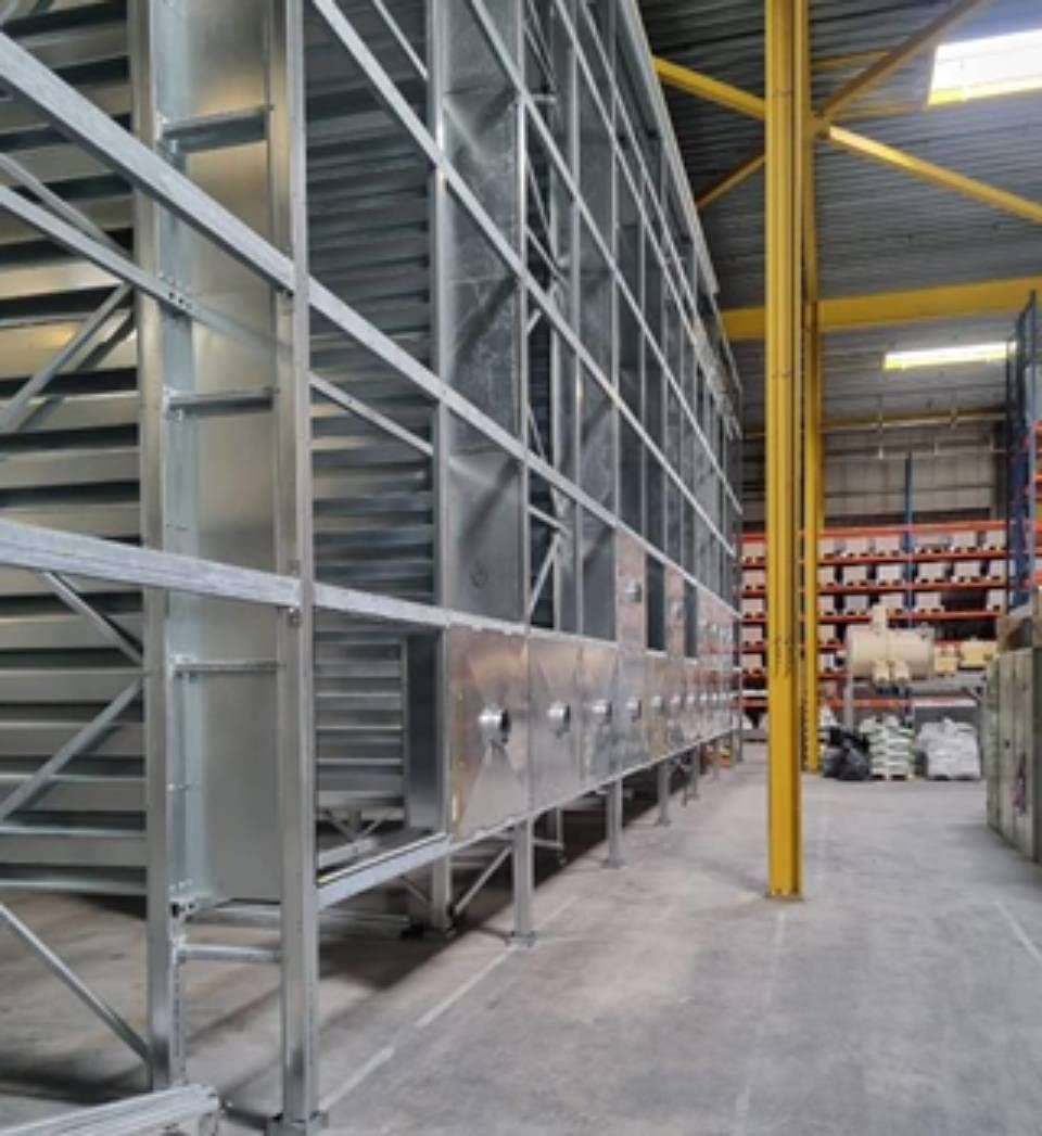 Metallregalsystem in einem Lagerhaus mit vertikalen Stützen und horizontalen Trägern.