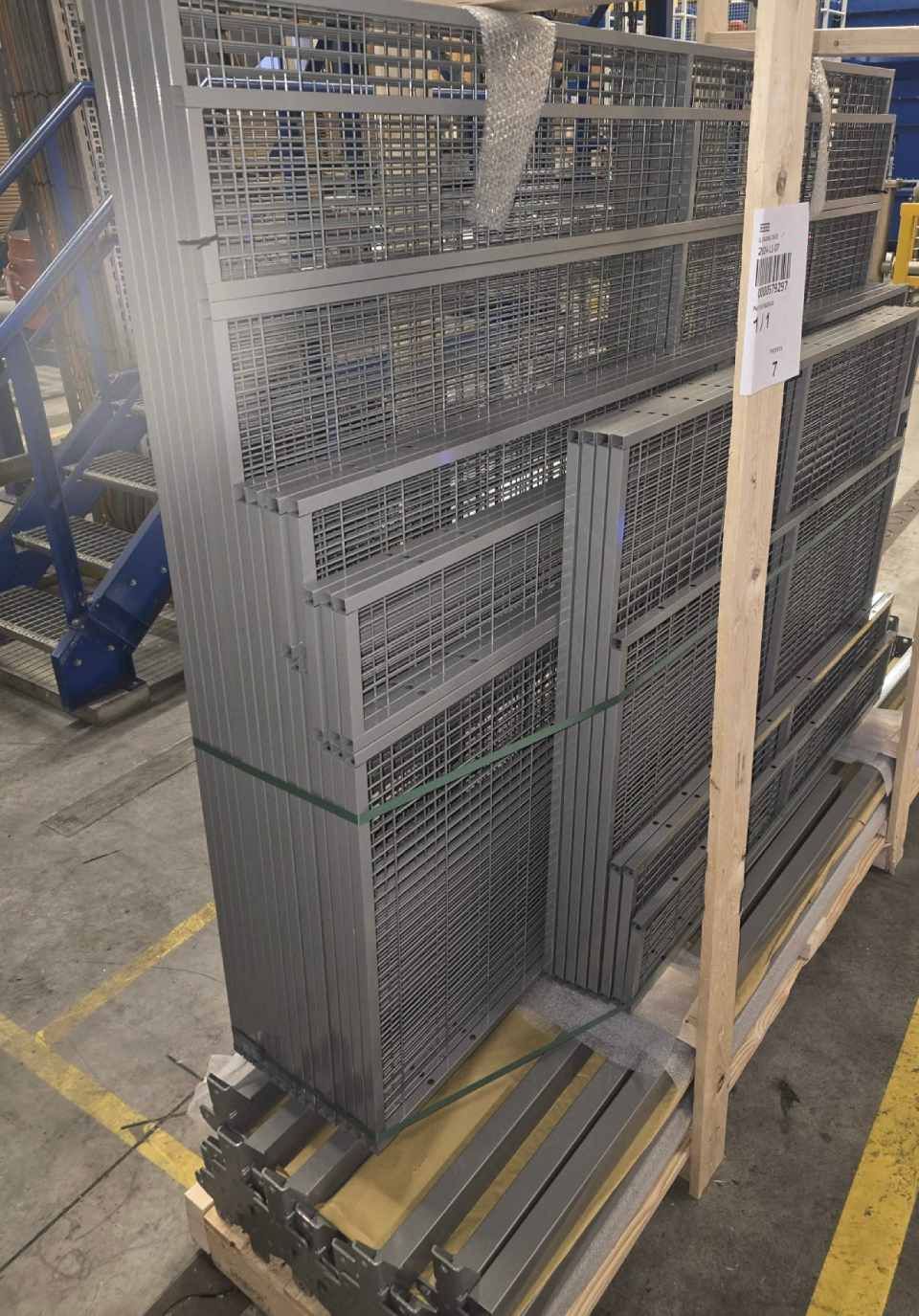 Auf einer Holzpalette gestapelte Metall-Drahtrahmen-Lagerbehälter.