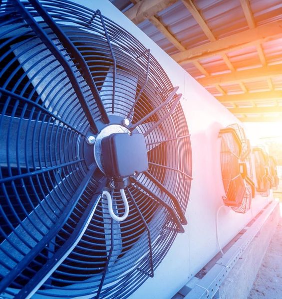 Un primer plano de un ventilador en un edificio con el sol brillando a través de él.