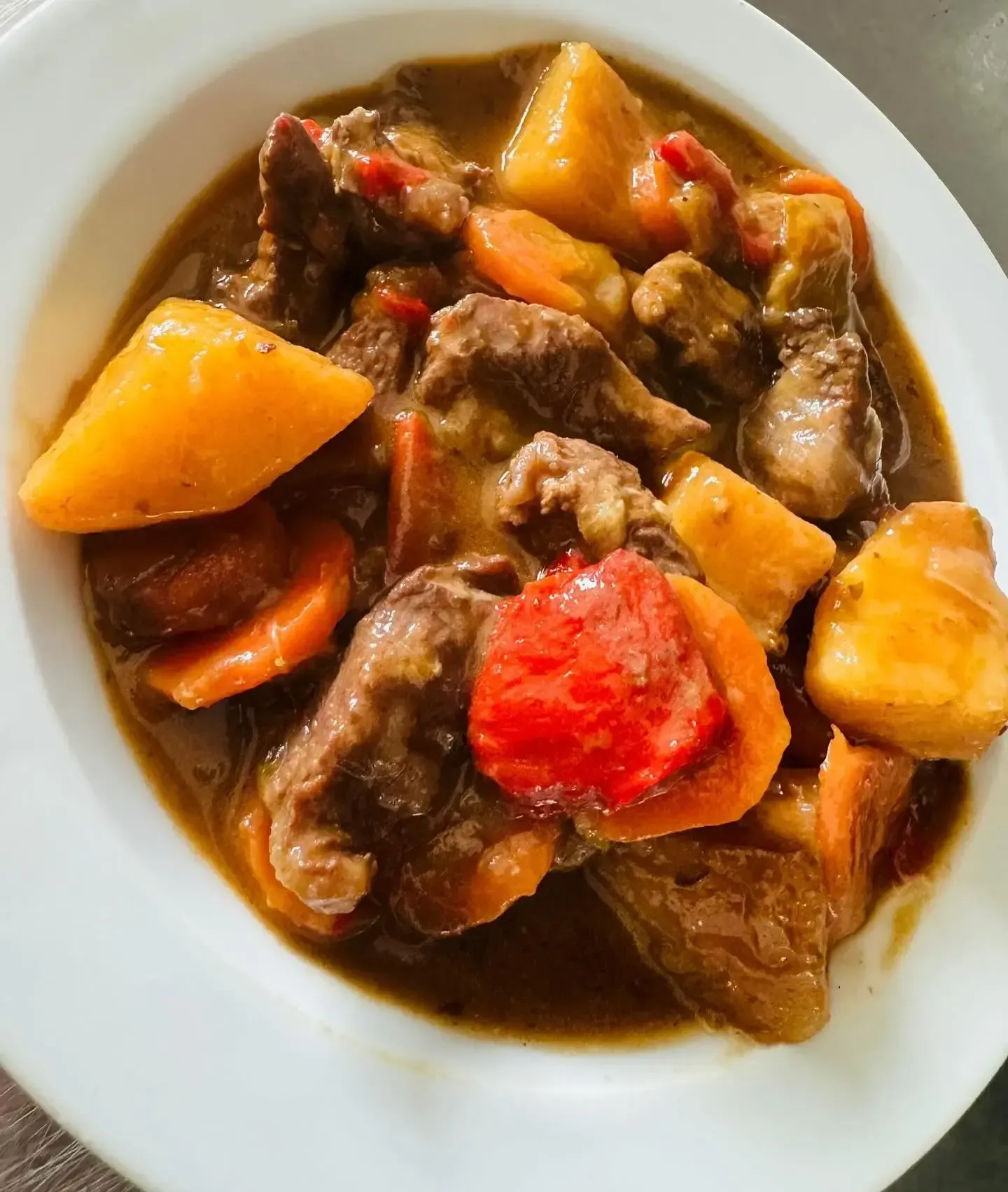 Estofado de ternera con patatas y zanahorias en un cuenco blanco.