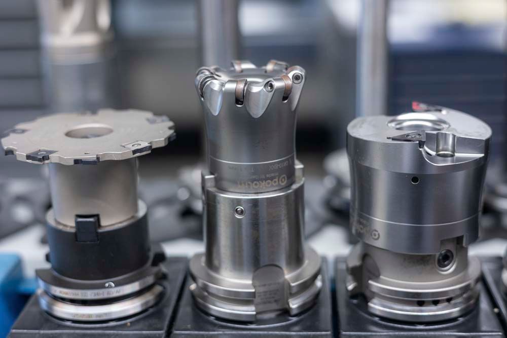 Drei Metallstücke liegen übereinander auf einem Tisch.