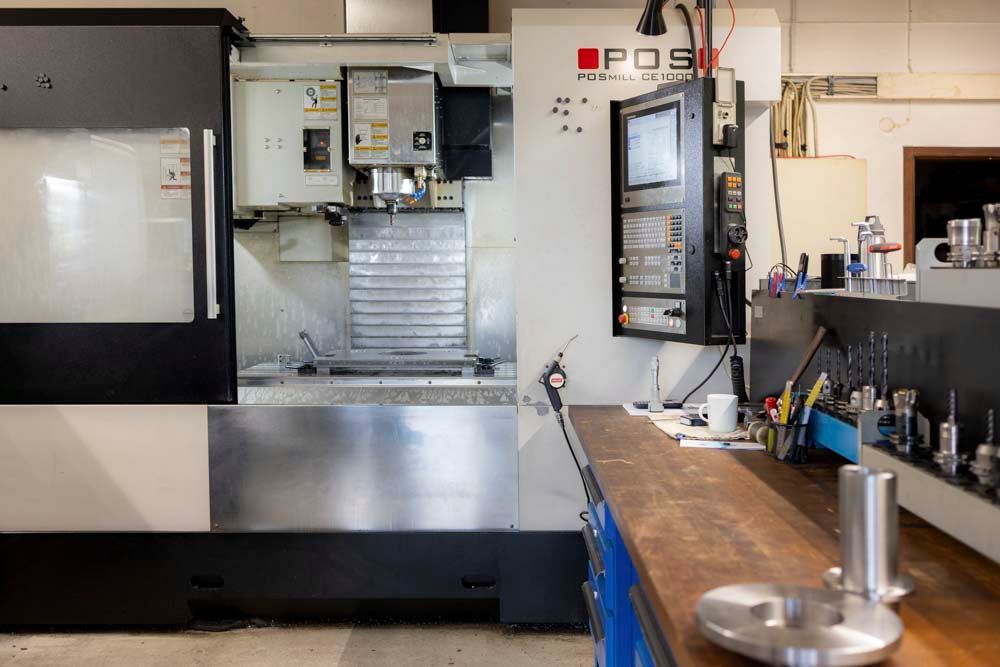 Eine CNC-Maschine, auf der das Wort „pos“ steht