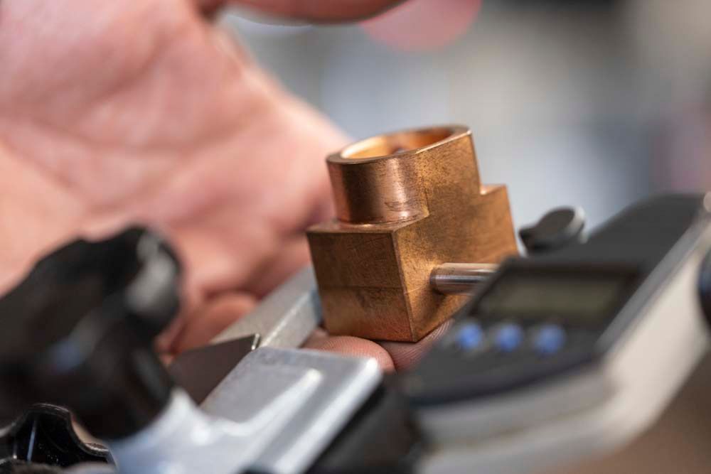 Eine Nahaufnahme einer Person, die ein Stück Metall in der Hand hält.