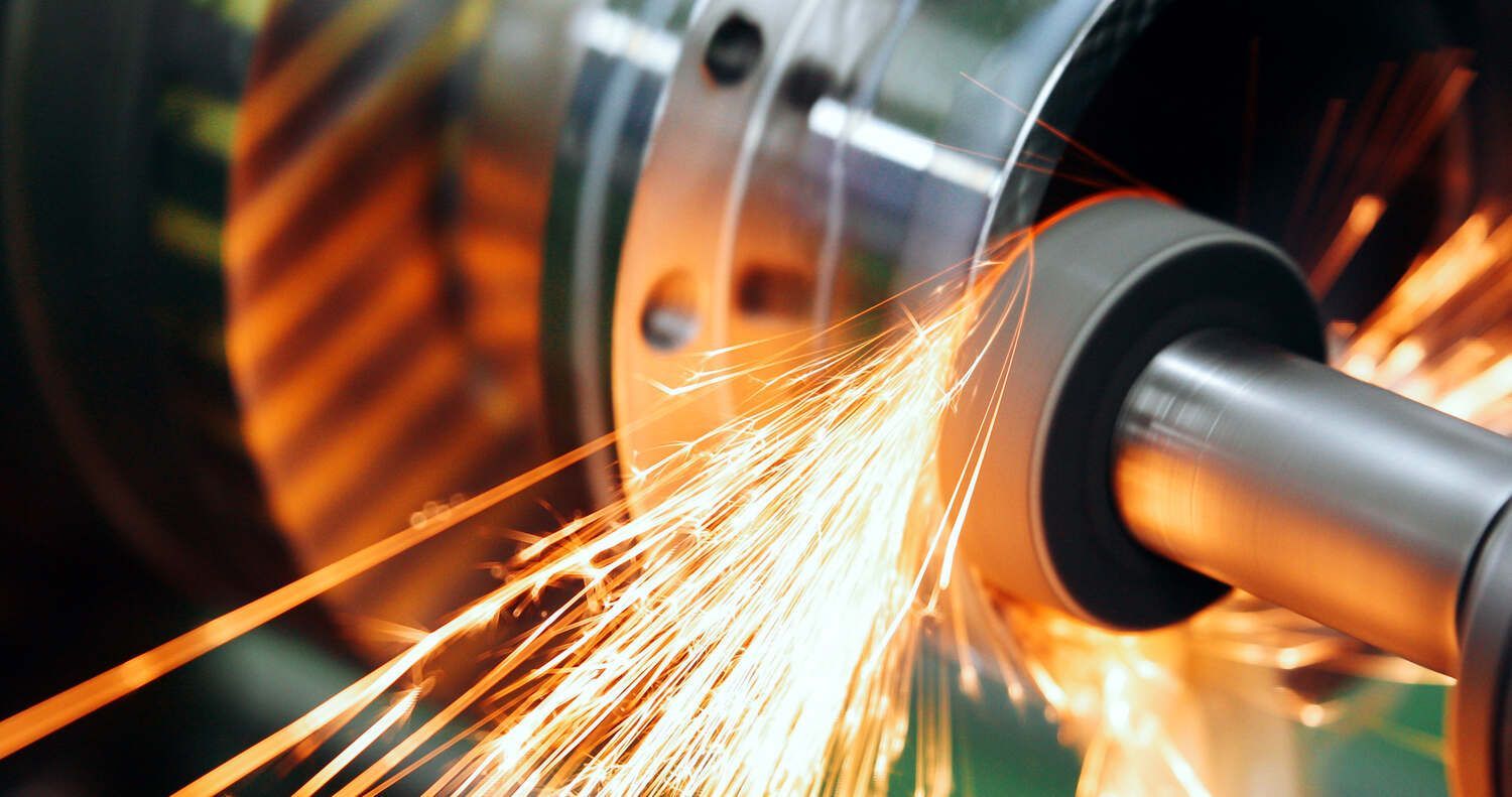 Eine CNC-Maschine schneidet ein Stück Metall, wobei Funken austreten.