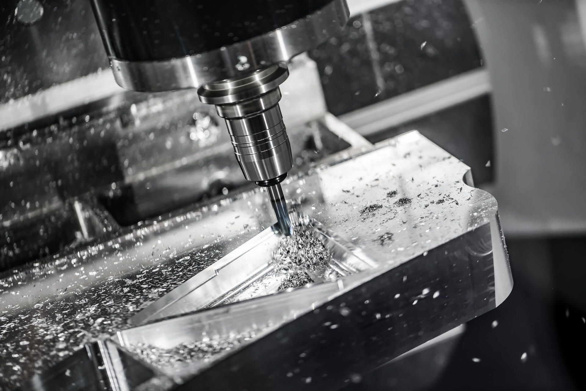 In einer Fabrik schneidet eine CNC-Maschine ein Stück Metall.