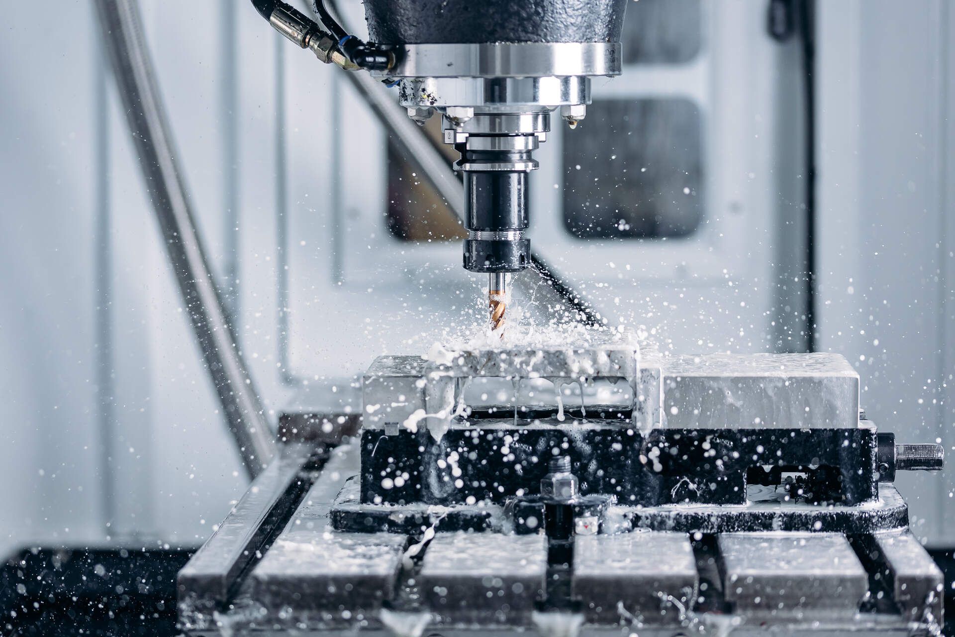 In einer Fabrik schneidet eine CNC-Maschine ein Stück Metall.