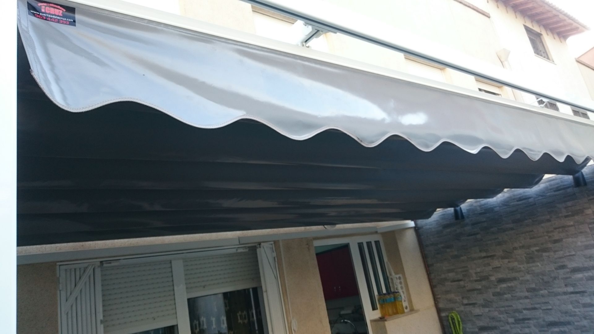 Un toldo blanco está en el costado de un edificio.