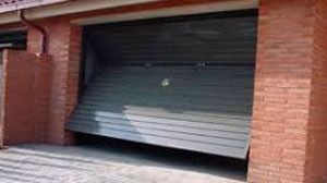 Una puerta de garaje está abierta en un edificio de ladrillo.