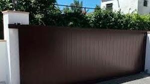 Una puerta corrediza marrón está al lado de una pared blanca.