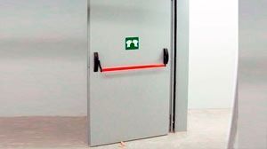 Una puerta blanca con una manija roja y una señal de salida verde.