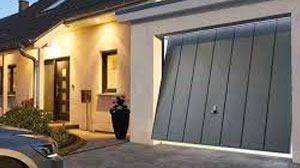 Un coche está aparcado delante de una puerta de garaje que está abierta.