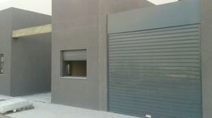 Una puerta de garaje con una ventana en el costado de un edificio.