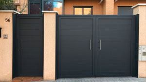 Una puerta negra está situada delante de una casa.