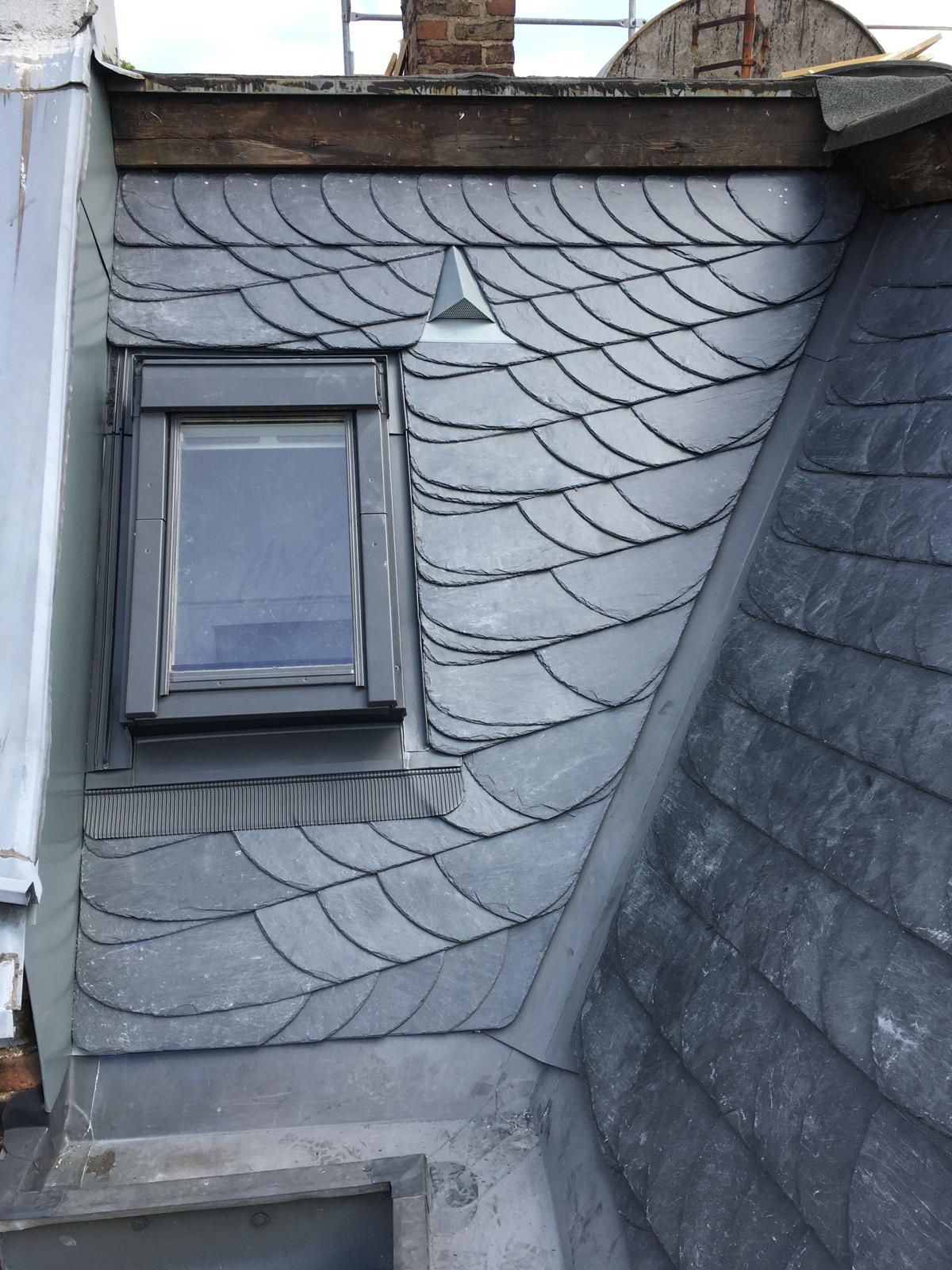 Schieferdach mit Dachgaube; grau und schwarz.