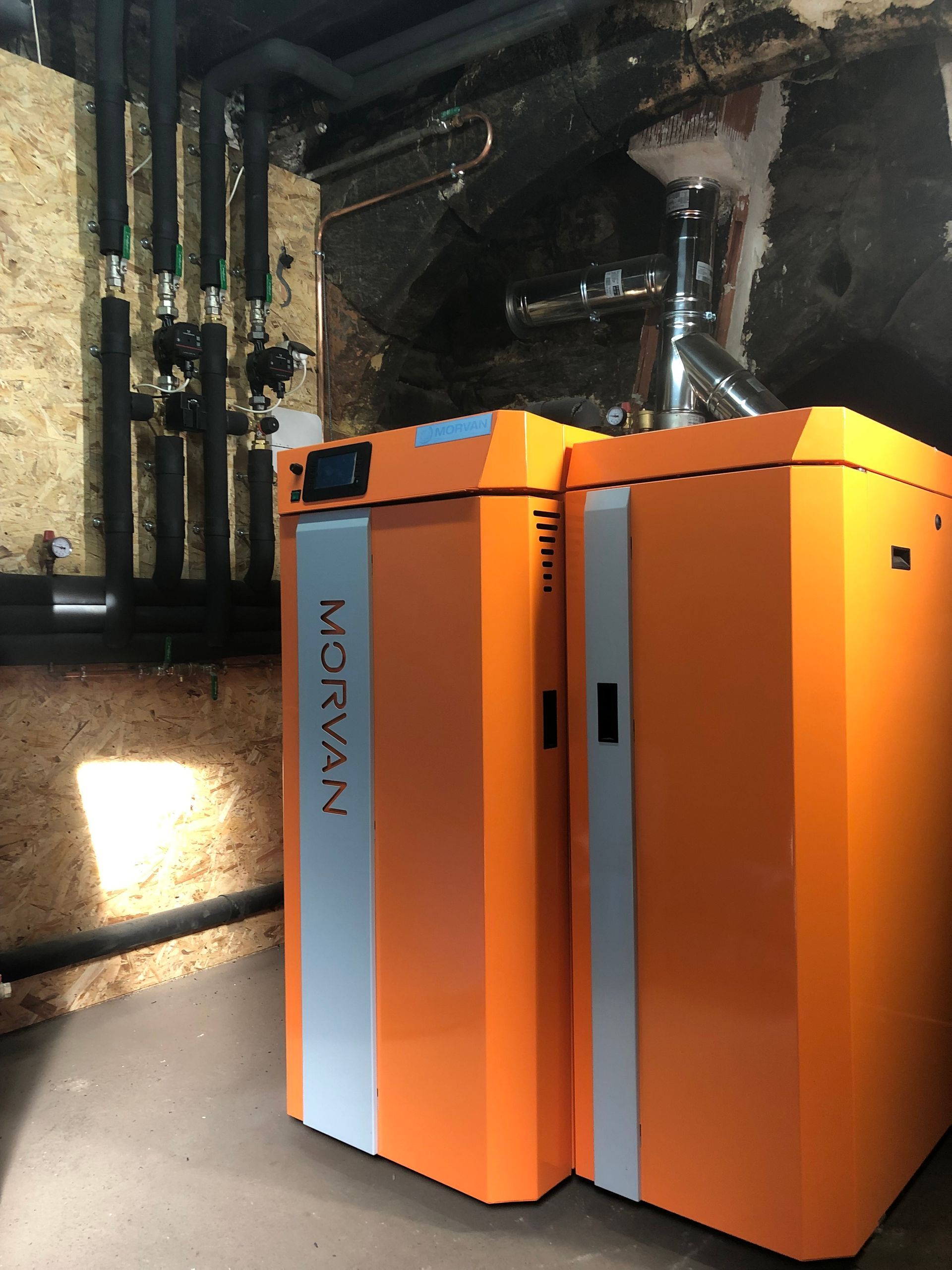 Unité de climatisation blanche fixée sur un mur beige au-dessus d'une étagère.