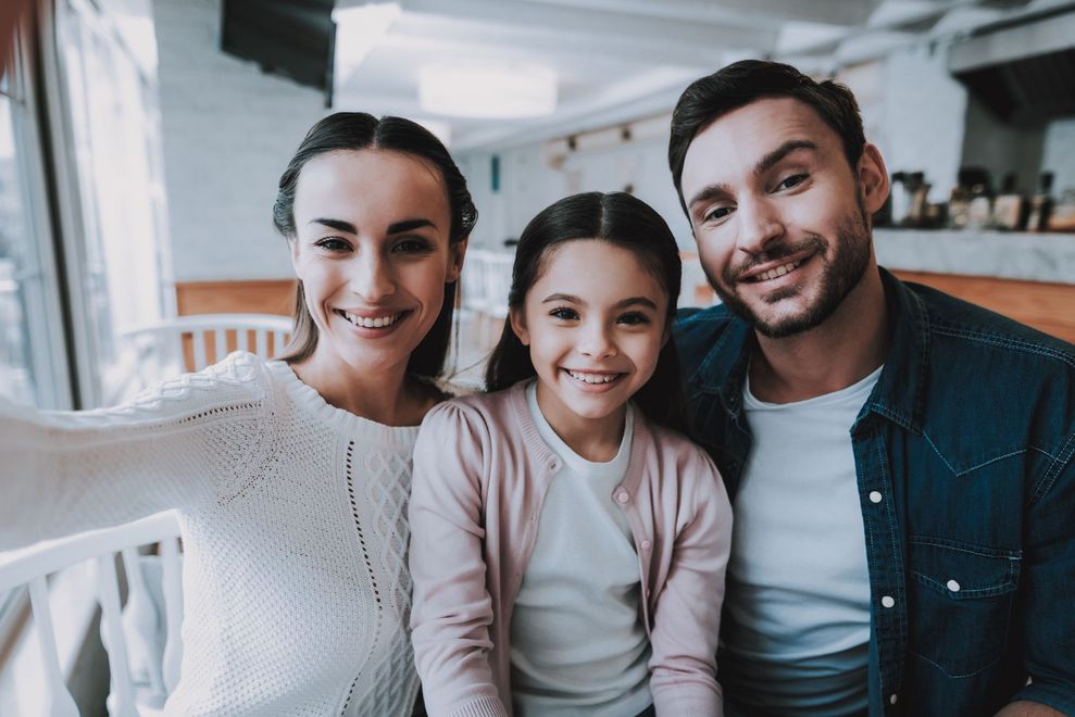 Una familia se está tomando un selfie juntos en un restaurante.