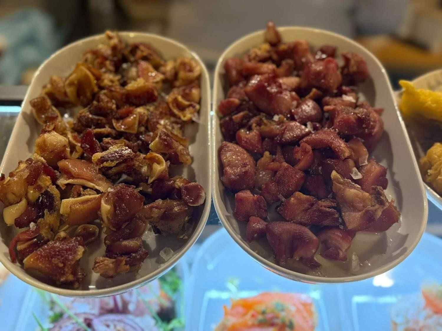 Dos platos ovalados que contienen trozos de cerdo cocidos, uno de color marrón dorado y el otro de color marrón rojizo.