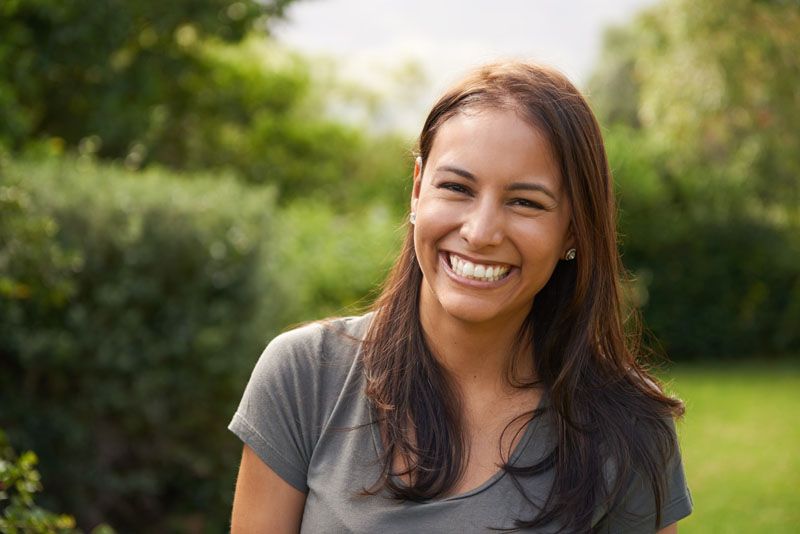 Femme souriante dans un jardin