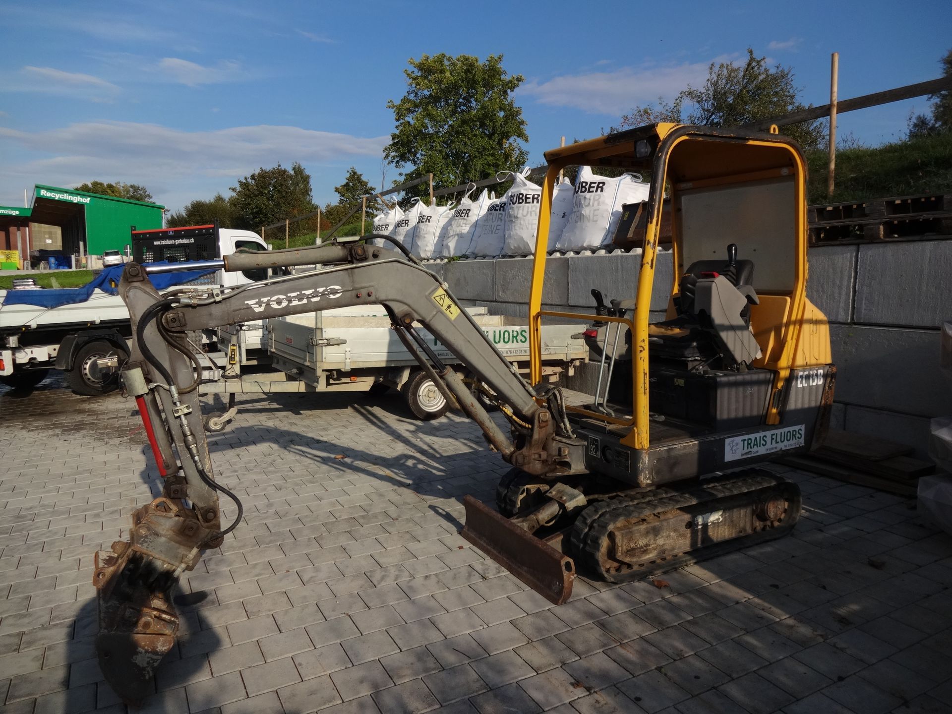 Gärtnerfahrzeug in Winkel, beladen mit Pflanzen und Geräten.