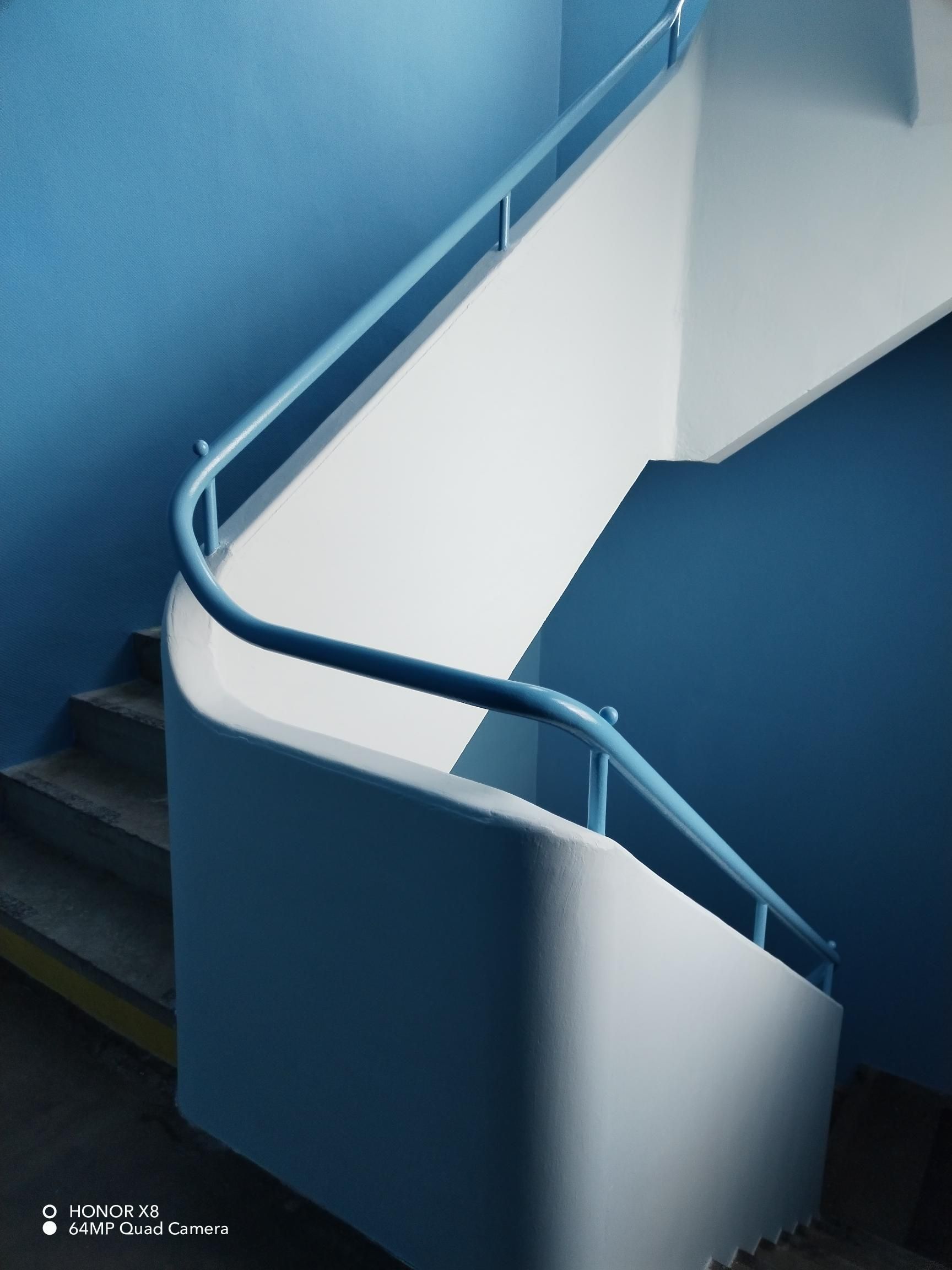 Peinture bleue du garde-corps d'un escalier de collège