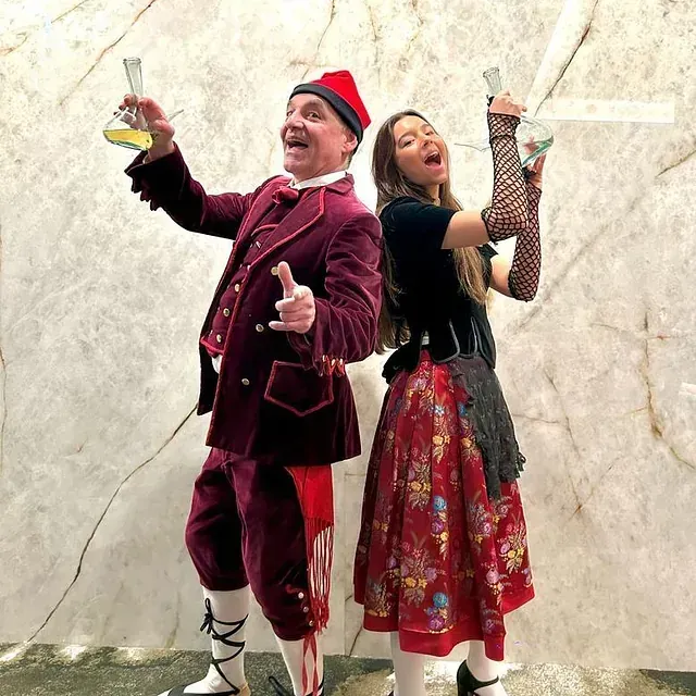 Un hombre y una mujer de pie uno al lado del otro sosteniendo copas de vino.