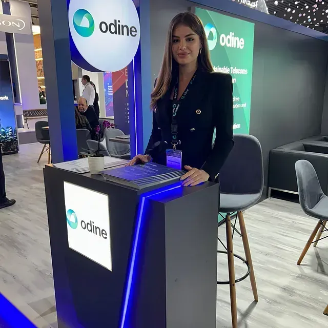 Una mujer está detrás de un escritorio que tiene escrito Odine.