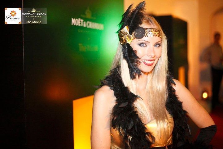 Una mujer con un vestido dorado y plumas negras en la cabeza.
