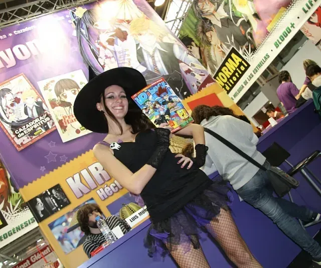 Una mujer disfrazada de bruja se encuentra frente a un cartel que dice norma