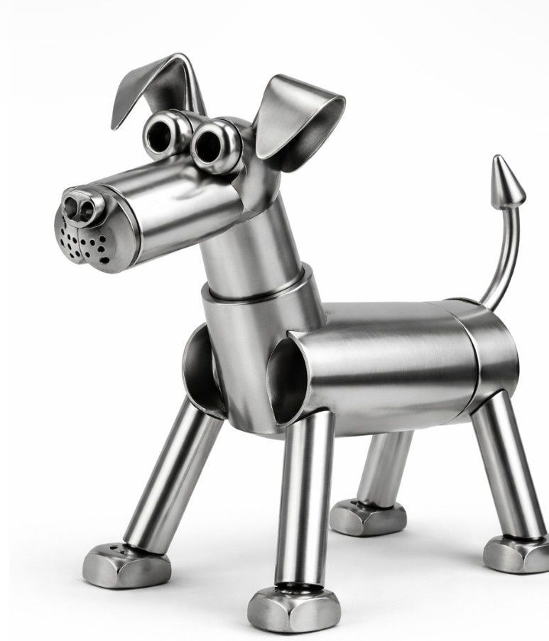 Figura de perro de metal hecha de tuercas y tornillos, plateada con cola rizada y orejas caídas sobre un fondo blanco.