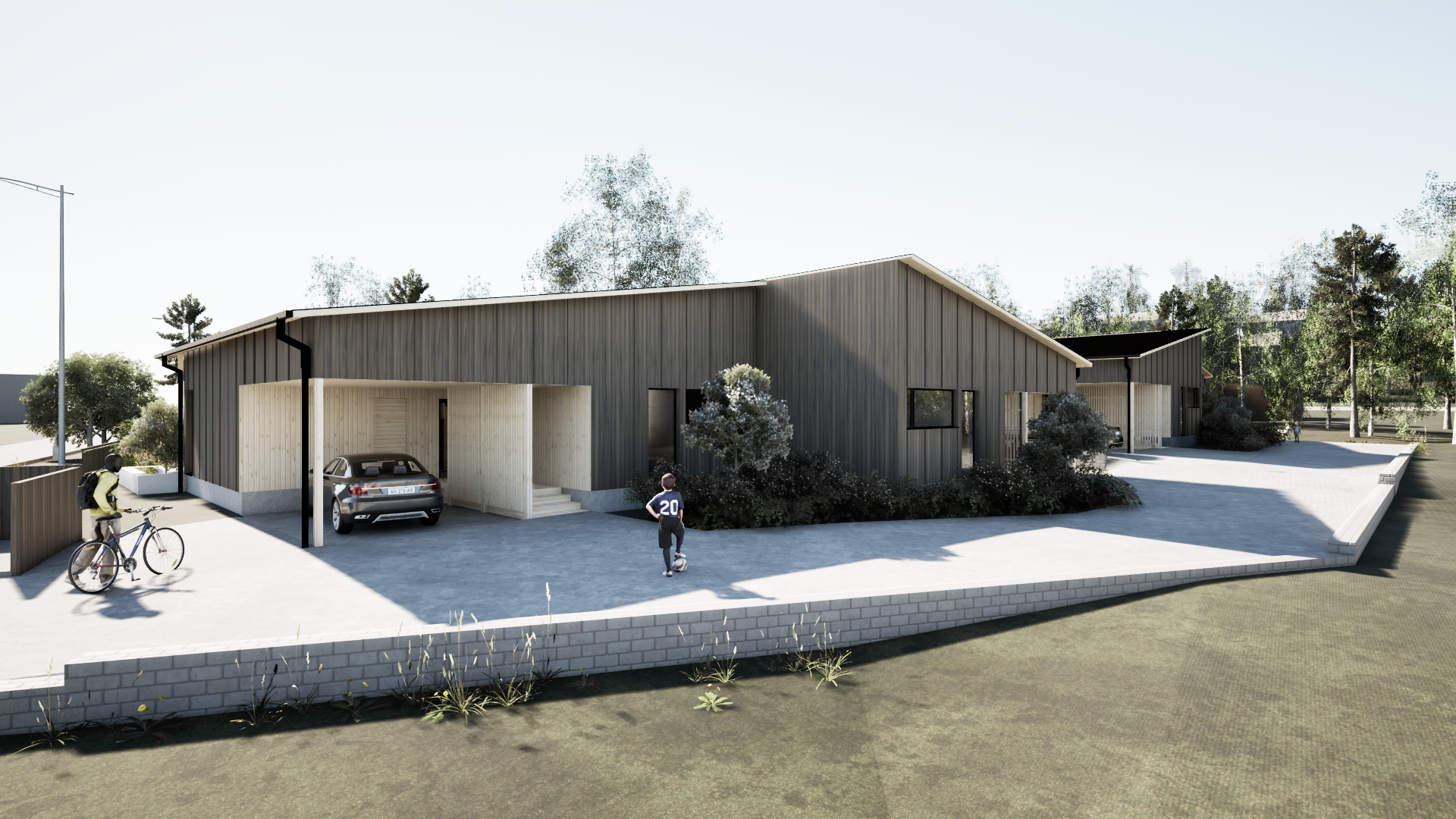 Moderni, harmaapaneloitu talo, jossa on autokatos, pysäköity auto ja ihmisiä päällystetyn ajotien lähellä nurmikolla, avoimella paikalla.