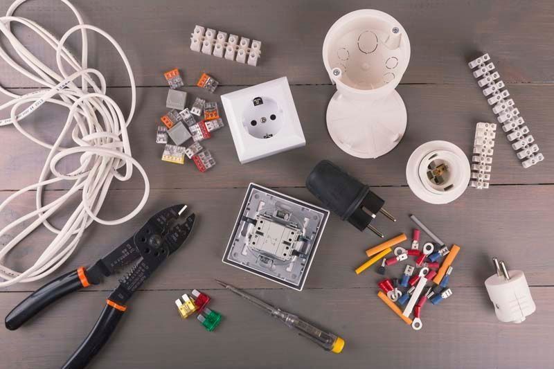 Una mesa de madera cubierta con componentes eléctricos y herramientas.