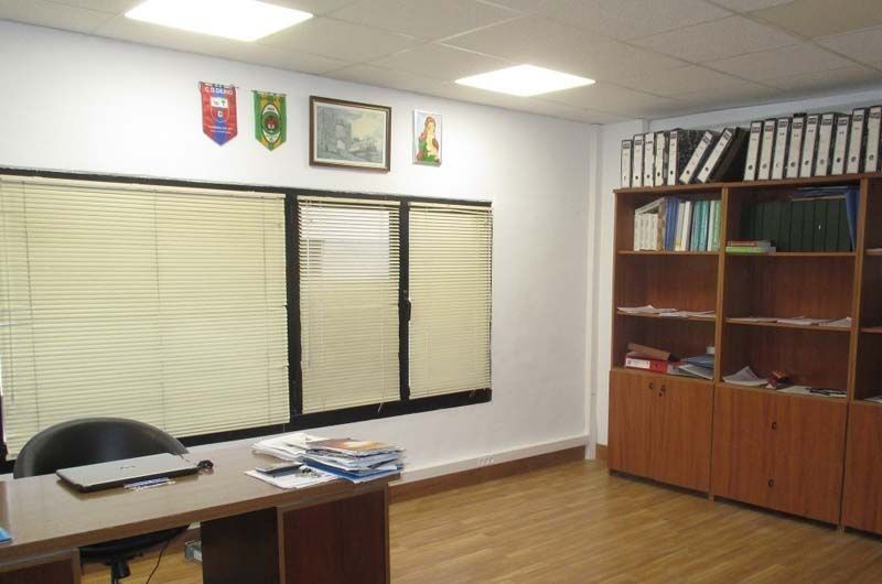 Una habitación con un escritorio y estantes llenos de carpetas.