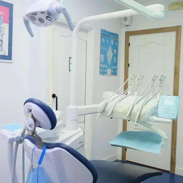 Un consultorio dental con un sillón dental y equipo dental.