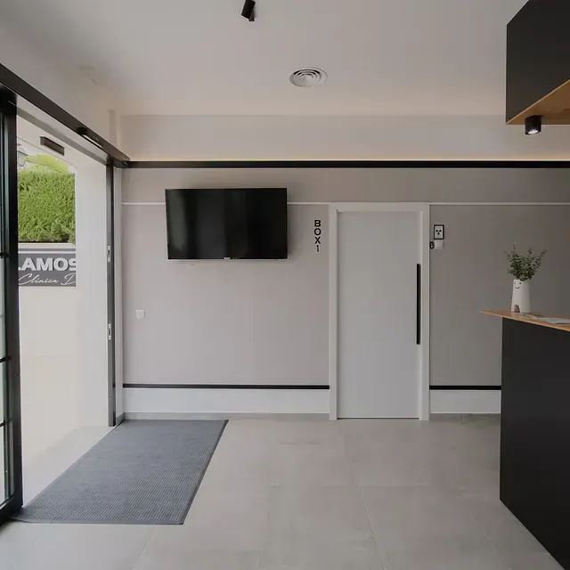 Una sala de estar con un televisor de pantalla plana colgado en la pared.