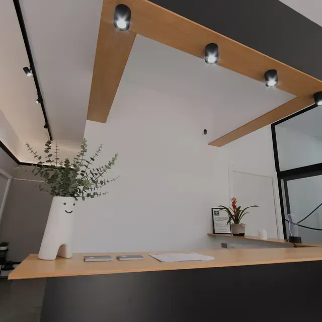 Un mostrador de recepción con un jarrón de flores encima.